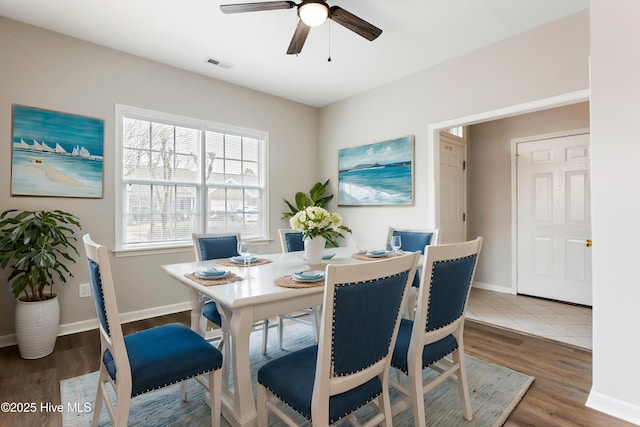 dining space featuring a ceiling fan, wood finished floors, and baseboards