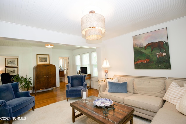 living room with light hardwood / wood-style floors and a notable chandelier