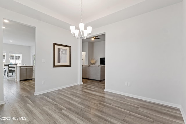 unfurnished room with an inviting chandelier and light hardwood / wood-style floors