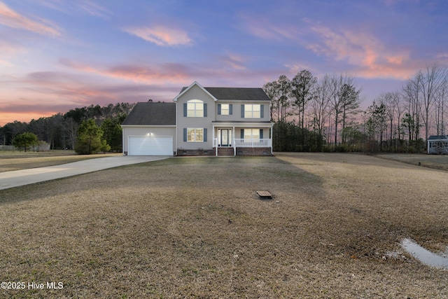 view of front of property featuring covered porch, a garage, and driveway