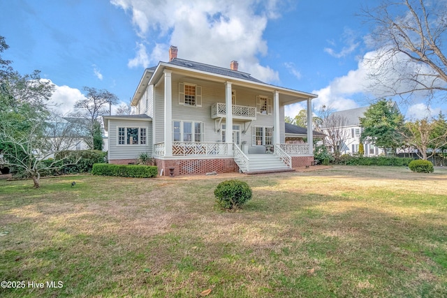 view of front of property with a front yard and a balcony