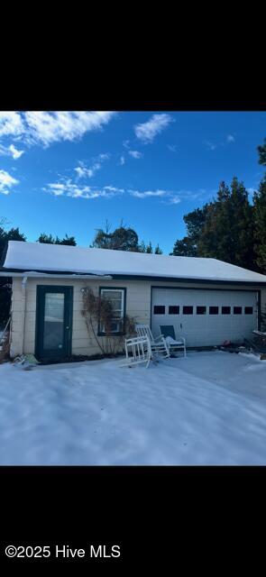 exterior space with a garage and an outbuilding