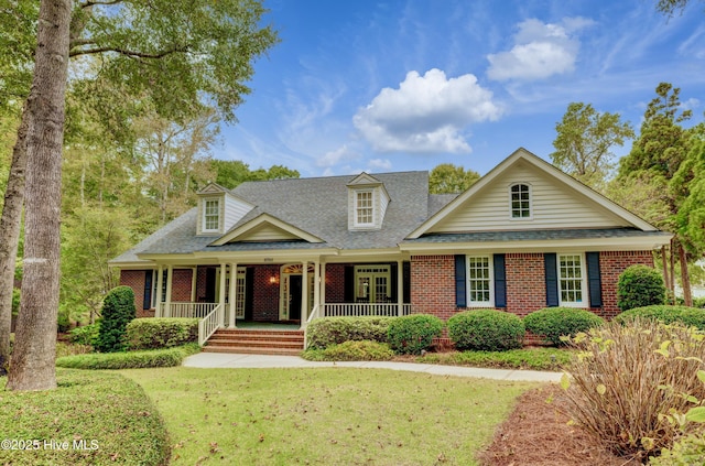 cape cod-style house featuring covered porch and a front yard