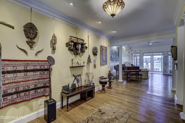 hall featuring ornamental molding, decorative columns, and wood-type flooring