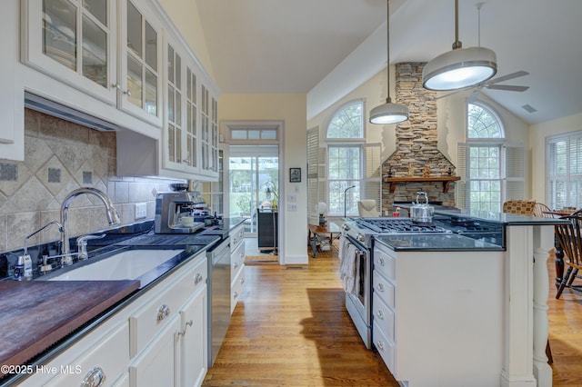 kitchen with hanging light fixtures, appliances with stainless steel finishes, sink, and white cabinets