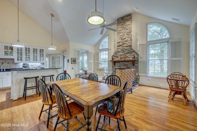 dining room featuring plenty of natural light, a fireplace, and light hardwood / wood-style flooring