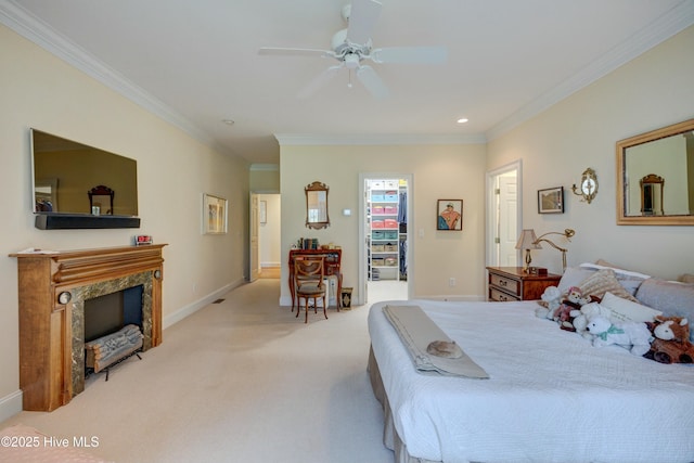 bedroom with ceiling fan, a walk in closet, ornamental molding, and light carpet