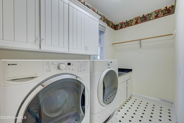 clothes washing area featuring cabinets and independent washer and dryer