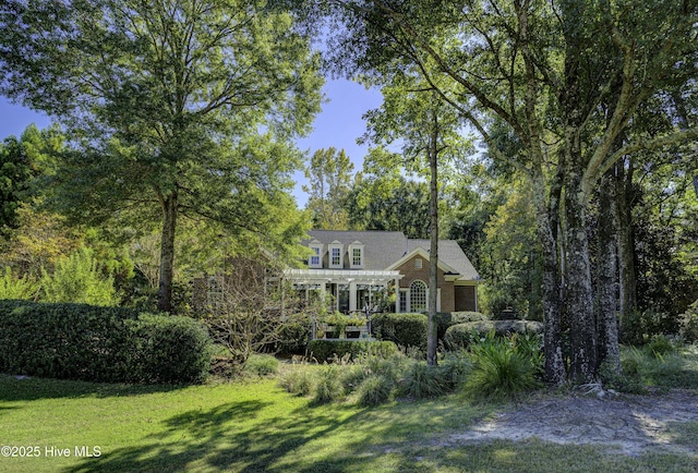 view of front of house featuring a front yard and a pergola