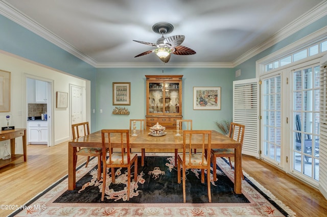 dining space featuring crown molding, a wealth of natural light, and light wood-type flooring