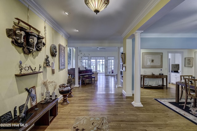 hall with decorative columns, ornamental molding, and hardwood / wood-style floors