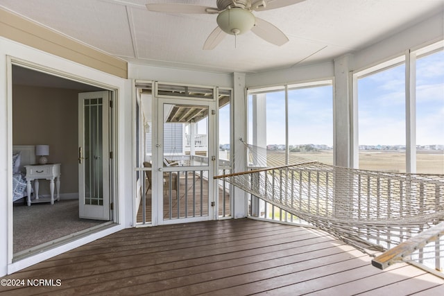 unfurnished sunroom featuring a ceiling fan