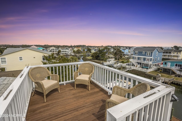 deck at dusk featuring a residential view