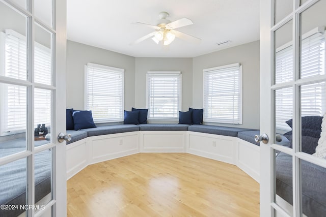 office with visible vents, ceiling fan, wood finished floors, french doors, and a decorative wall