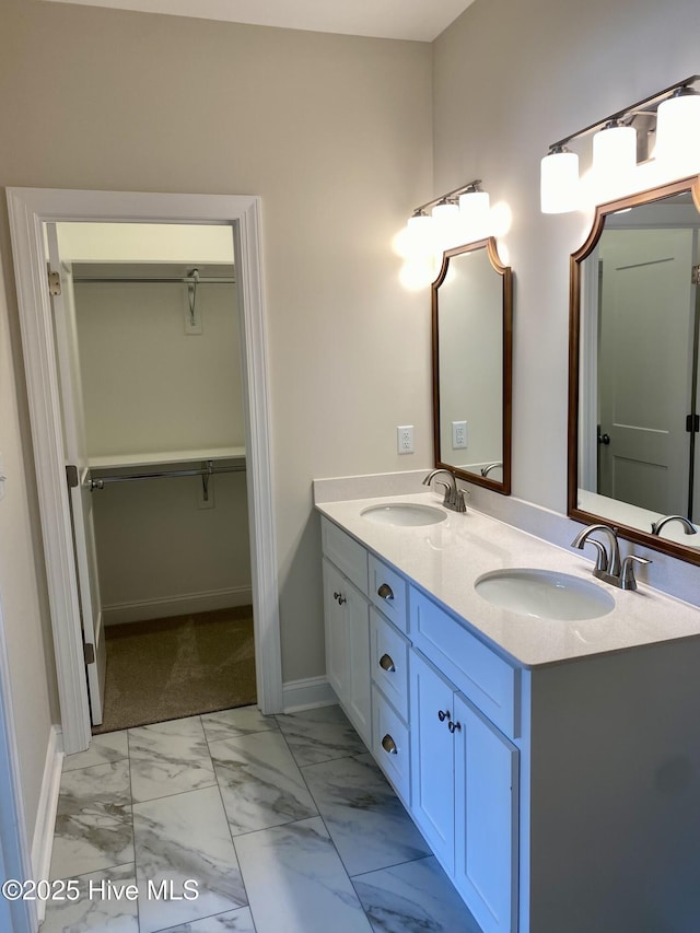 703 Henry Ln, Tarboro, NC 27886 - bathroom with double vanity, marble finish floor, a walk in closet, and a sink