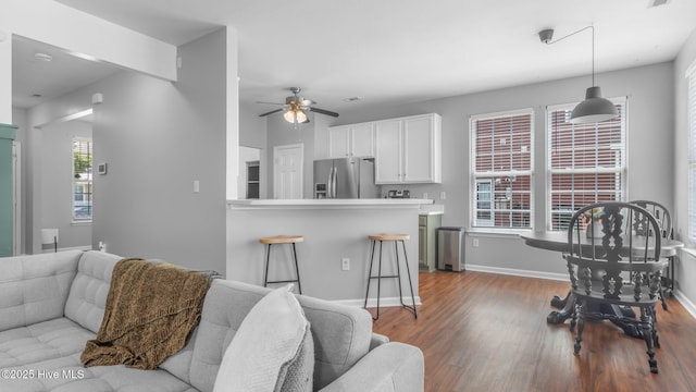 living room with ceiling fan and light wood-type flooring