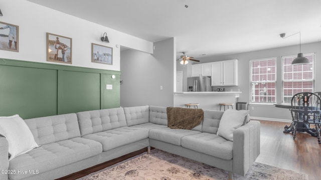 living room with ceiling fan and light wood-type flooring