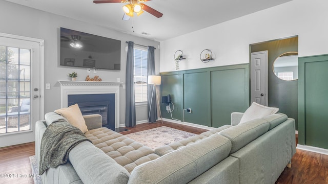 living room featuring ceiling fan and dark hardwood / wood-style flooring