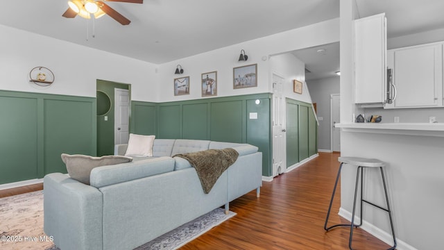 living room featuring dark wood-type flooring and ceiling fan