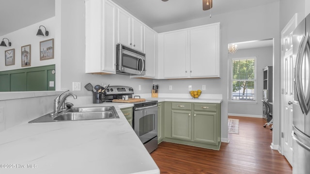 kitchen featuring sink, dark hardwood / wood-style floors, green cabinets, ceiling fan, and stainless steel appliances