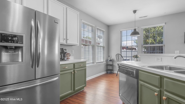 kitchen featuring white cabinetry, appliances with stainless steel finishes, a wealth of natural light, and green cabinets