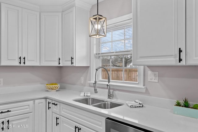 kitchen with pendant lighting, sink, stainless steel dishwasher, and white cabinets