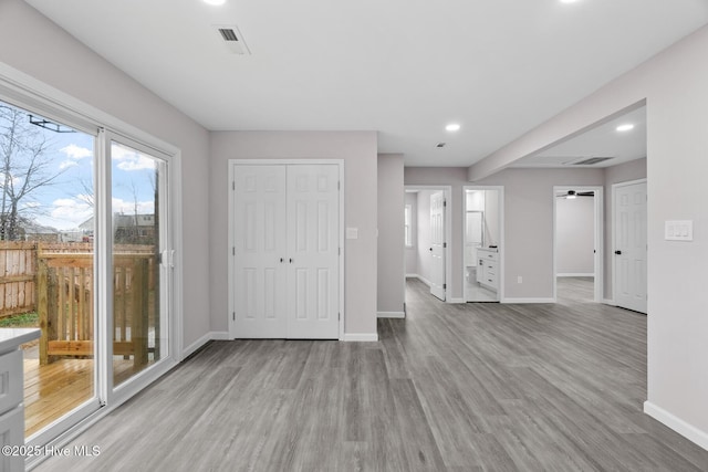 interior space featuring connected bathroom, access to exterior, and light wood-type flooring