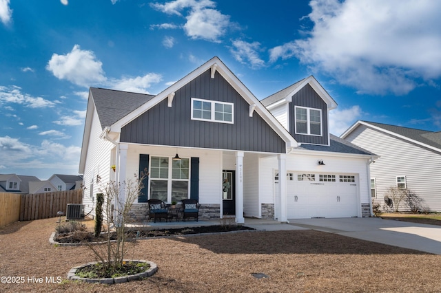 view of front of property with cooling unit, a garage, and covered porch