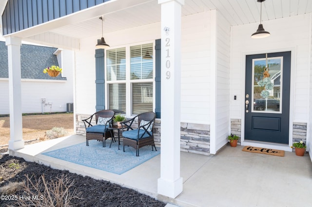 doorway to property with central AC and a porch