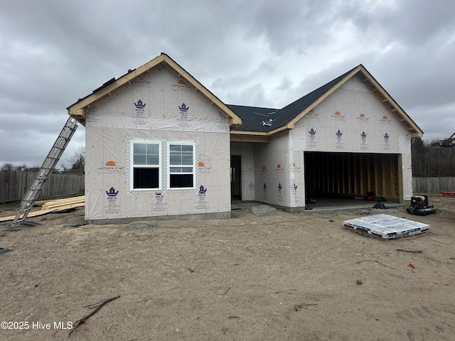 property under construction with a garage and fence