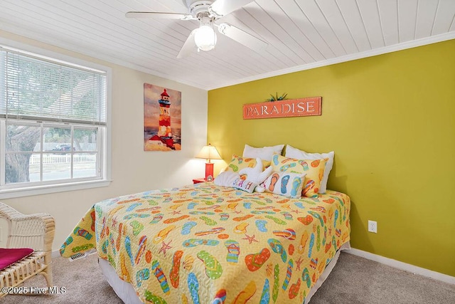 carpeted bedroom with ceiling fan, ornamental molding, and wooden ceiling