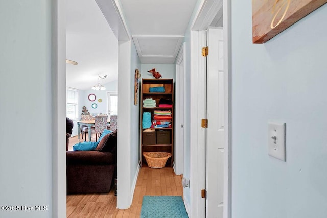 hall with lofted ceiling and light hardwood / wood-style floors