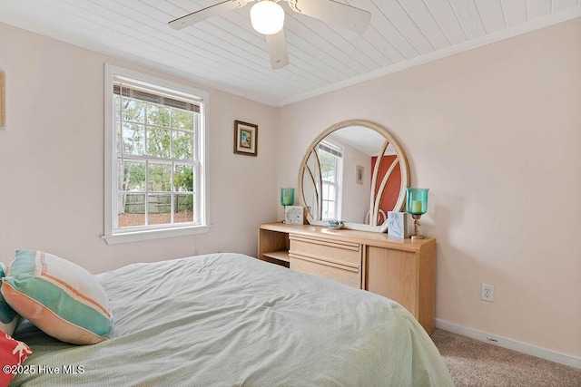 bedroom featuring wood ceiling, light colored carpet, ornamental molding, and ceiling fan