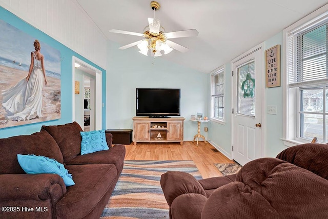 living room with vaulted ceiling, ceiling fan, and light wood-type flooring