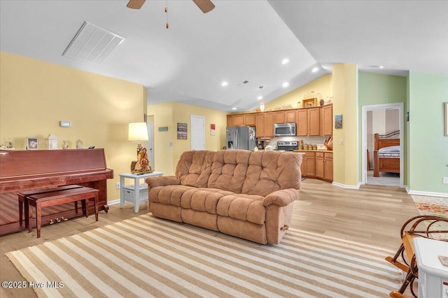 living room featuring ceiling fan, light hardwood / wood-style floors, and vaulted ceiling