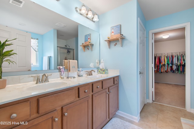 bathroom with vanity, an enclosed shower, and tile patterned flooring