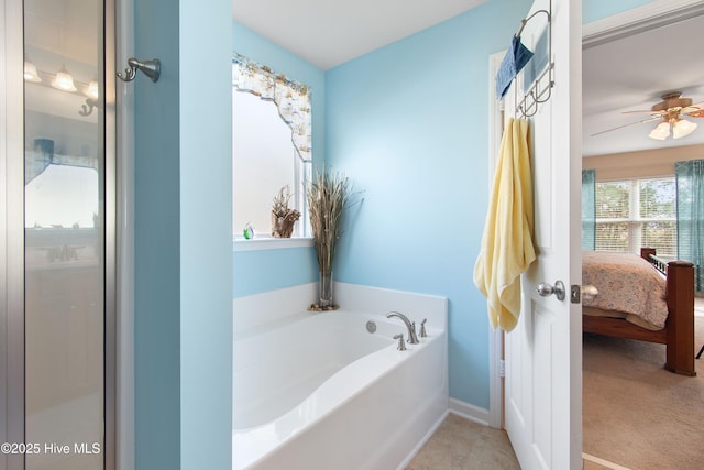 bathroom with ceiling fan, tile patterned floors, and a washtub