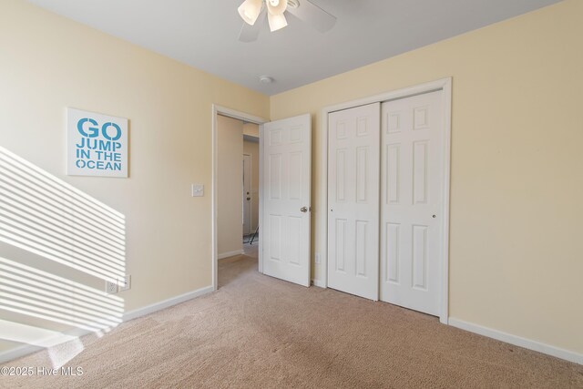 unfurnished bedroom featuring light carpet, a closet, and ceiling fan