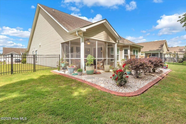 back of property with a sunroom, ceiling fan, and a lawn