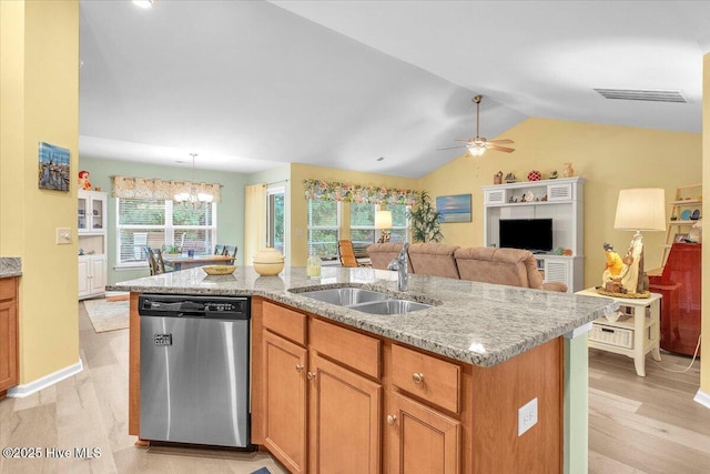 kitchen featuring sink, light stone counters, dishwasher, an island with sink, and light hardwood / wood-style floors