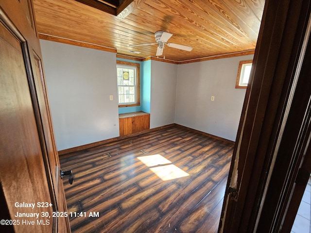 spare room with dark wood-type flooring, ceiling fan, crown molding, and wooden ceiling