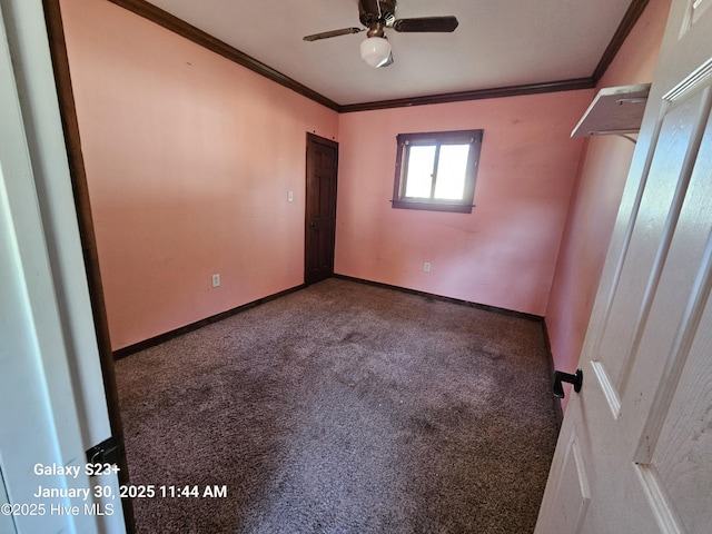 empty room with crown molding, ceiling fan, and carpet