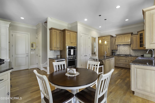 dining space with ornamental molding, dark hardwood / wood-style flooring, and sink