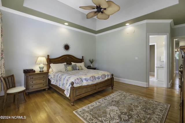 bedroom with ornamental molding, ceiling fan, and light hardwood / wood-style floors