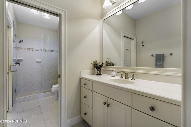 bathroom featuring vanity, tile patterned floors, toilet, and walk in shower