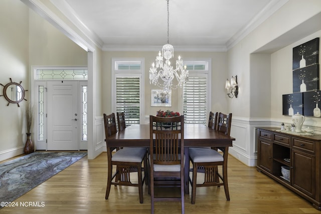 dining room with crown molding, an inviting chandelier, and light hardwood / wood-style floors