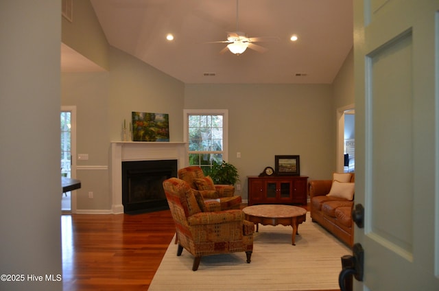 living room with hardwood / wood-style flooring, high vaulted ceiling, and ceiling fan