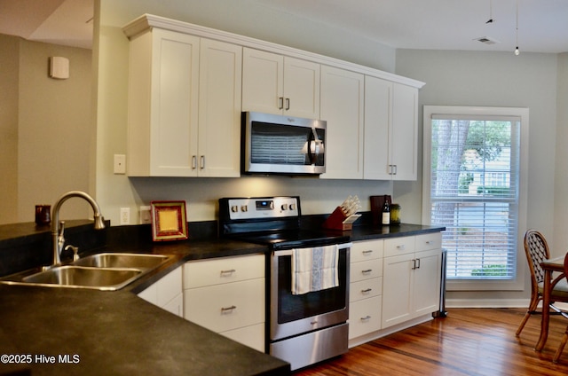 kitchen featuring stainless steel appliances, sink, a wealth of natural light, and white cabinets