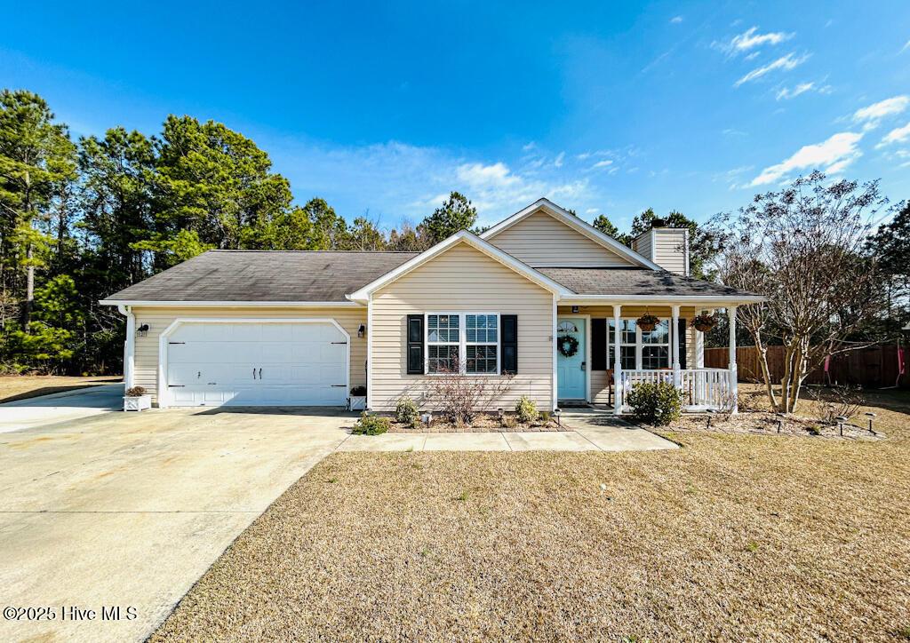 view of front of home featuring a garage, a front lawn, and a porch