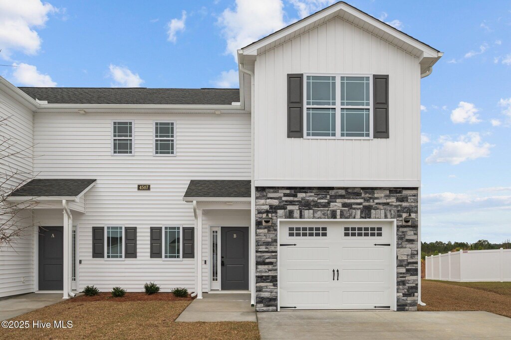 view of front facade with a garage, central AC, and a front lawn